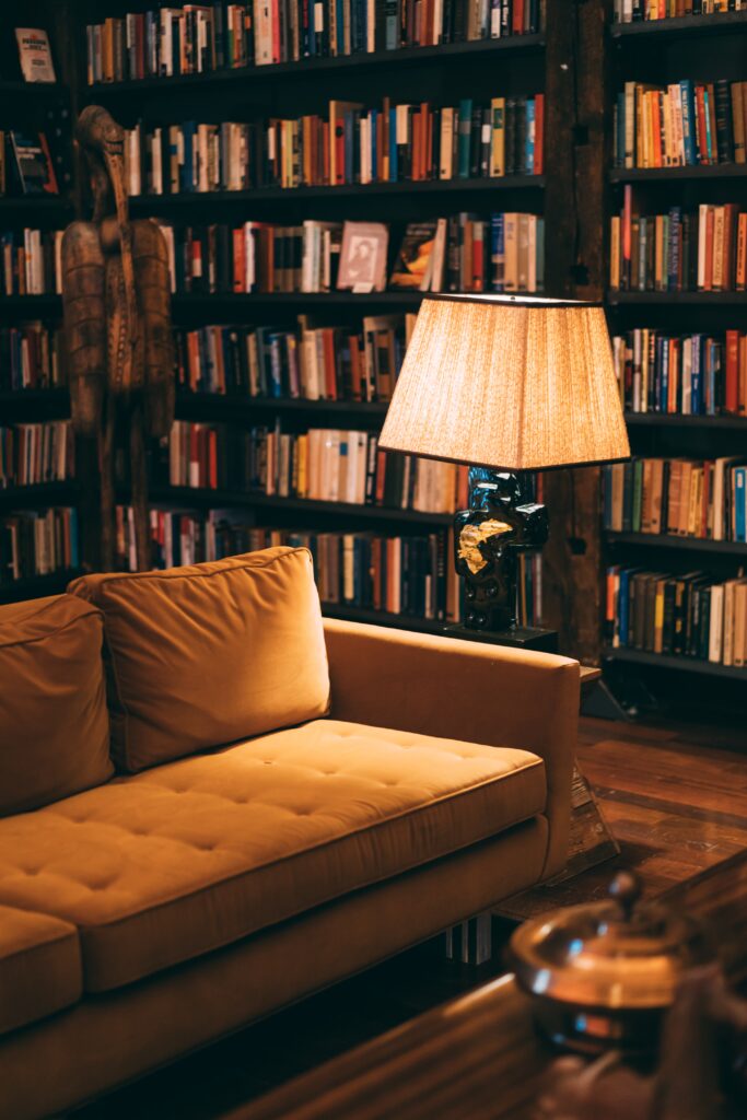 Unlock the Secret: How to Read Free English Books a sofa near a lamp surrounded by books is the perfect atmosphere to get cozy and read free books online or listen to audiobooks for free using the best reading apps